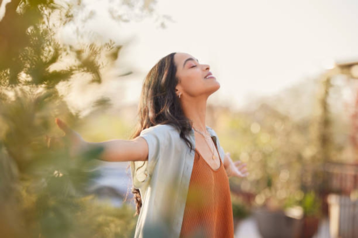 A woman breathing deeply outdoors in morning light